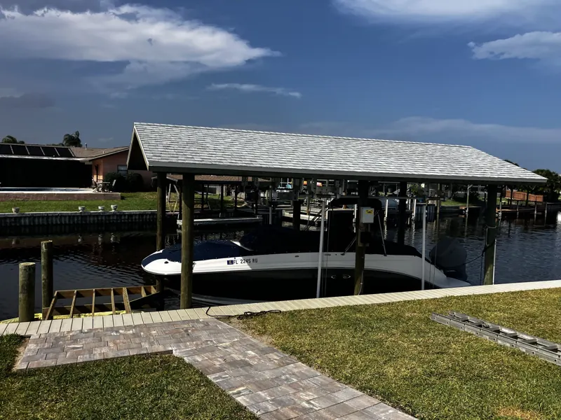 Boat raised on a lift under a boathouse roof